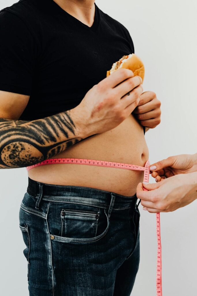 https://www.pexels.com/photo/man-with-hamburger-getting-his-waist-measured-5714314/